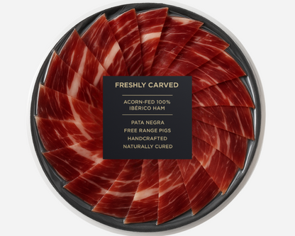Freshly Carved Acorn-Fed 100% Ibérico Ham Pata Negra - Hand-Sliced Spanish Jamón on Serving Plate