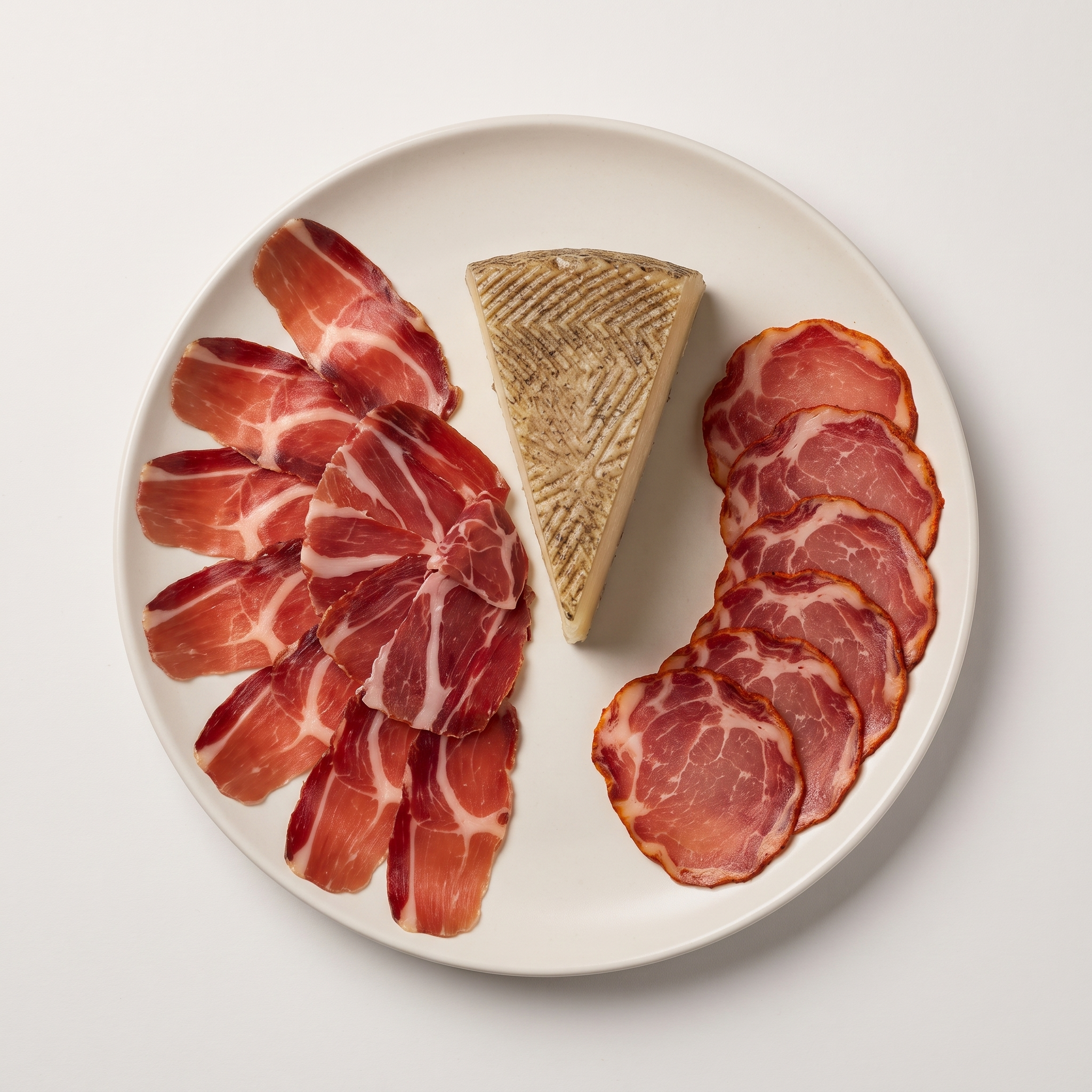 Bellota Charcuterie Selection — Jamón Ibérico, Lomo, and Manchego cheese plated with rosemary sprig and wooden spoon on linen